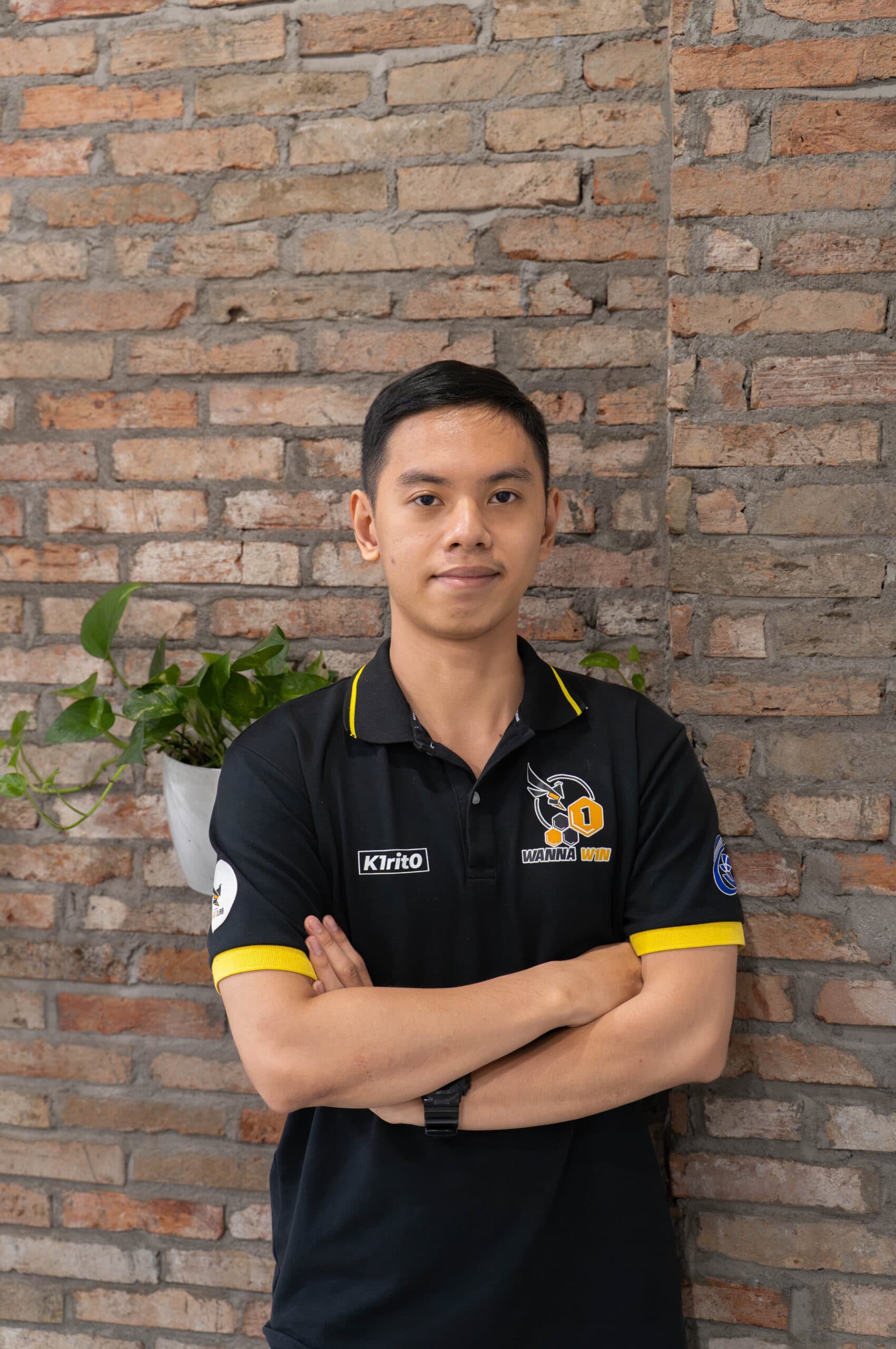 A TRG intern standing in front of a brick wall in the office