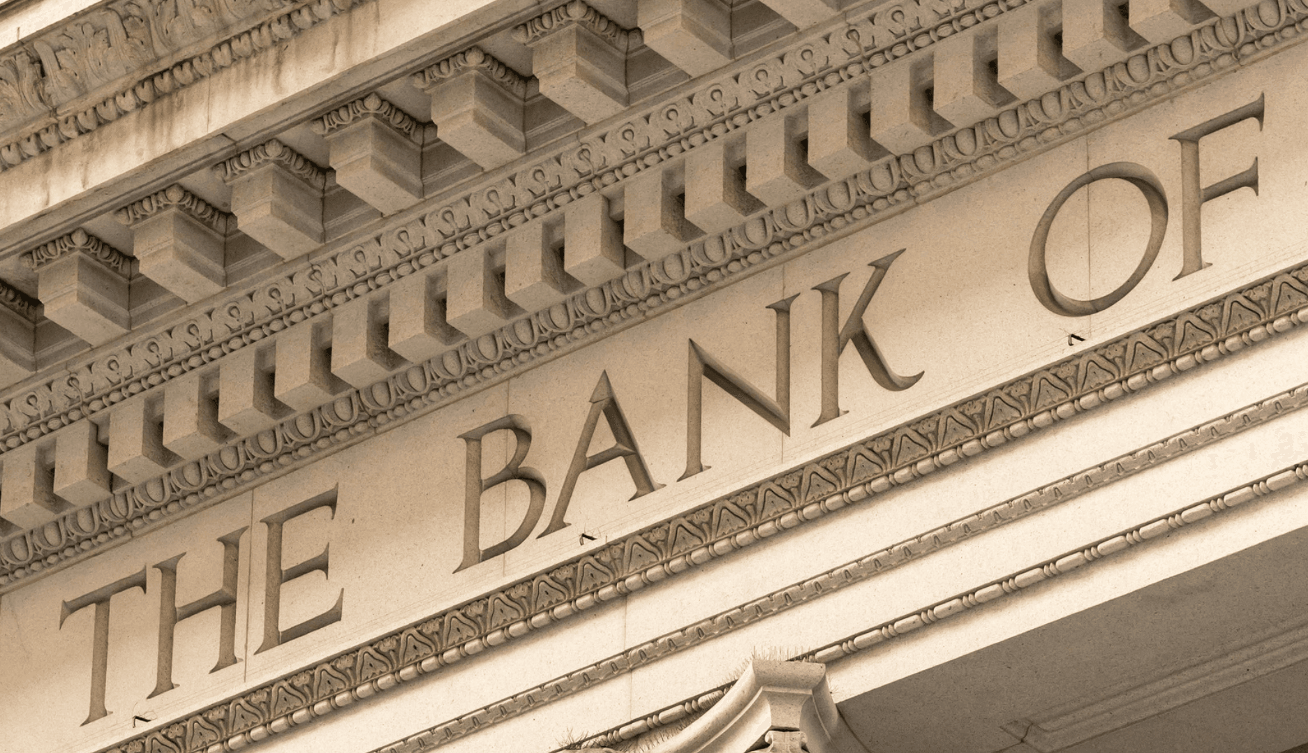 Carved stone lettering reading THE BANK OF on a neoclassical facade