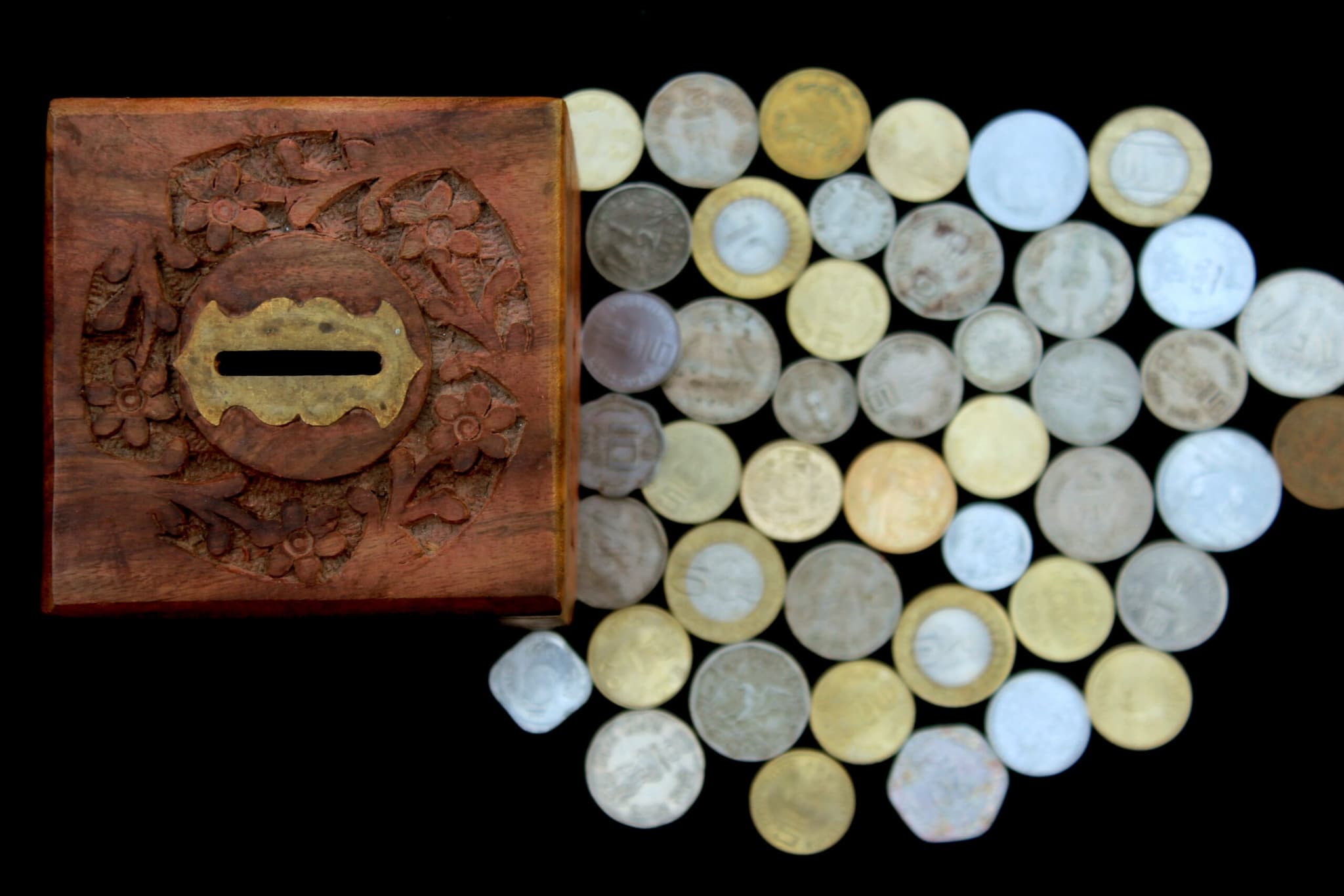 A spread of old coins beside an antique brass lock plate